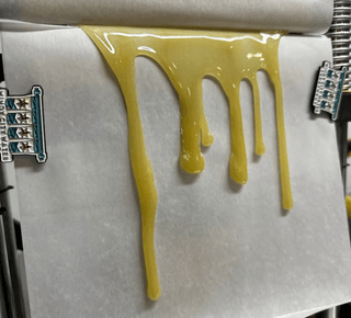 RG5 S1 rosin dripping from press with golden drips